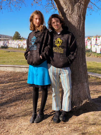 Both hoodies by a tree